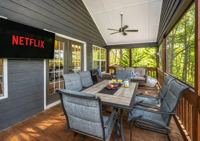 The screened porch does double duty — dinner with the lake in front of you, then pull up Netflix without ever going inside.