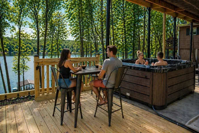 The outdoor bar table keeps the party going on the deck — pull up a chair, jump in the hot tub, pour something cold, and enjoy the endless lake views