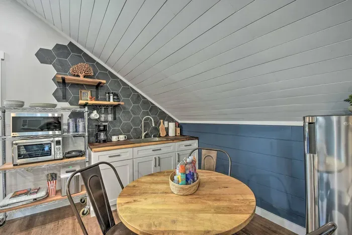 Relax and dine in the cozy sitting area near the well-equipped kitchen, featuring essential utilities such as a microwave and smart oven. Enjoy convenience and comfort in this cozy retreat 