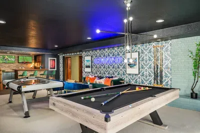 Pool table, air hockey, and lounging area make this a fun game room for the whole family.