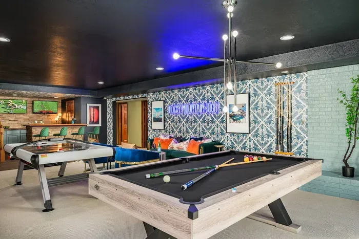Pool table, air hockey, and lounging area make this a fun game room for the whole family.