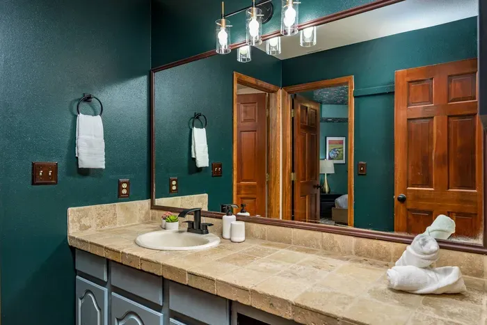 Downstairs bathroom with access from two different bedrooms as well as the hallway. Includes full shower and tub.