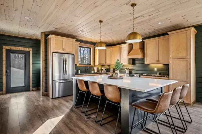 Spacious open-concept layout with leather seating, wood finishes.