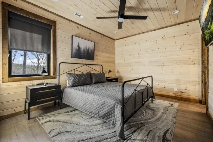 Rustic bedroom with wood finishes, forest views, and modern design.