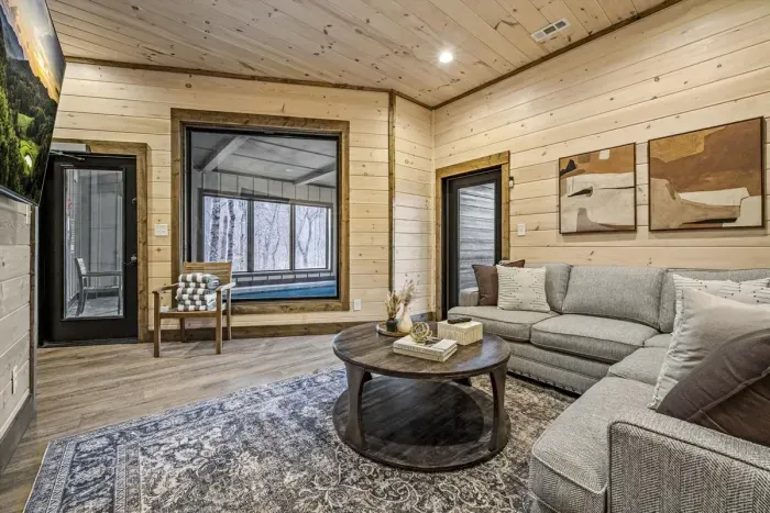 Enjoy forest views from this cozy cabin-style living room.