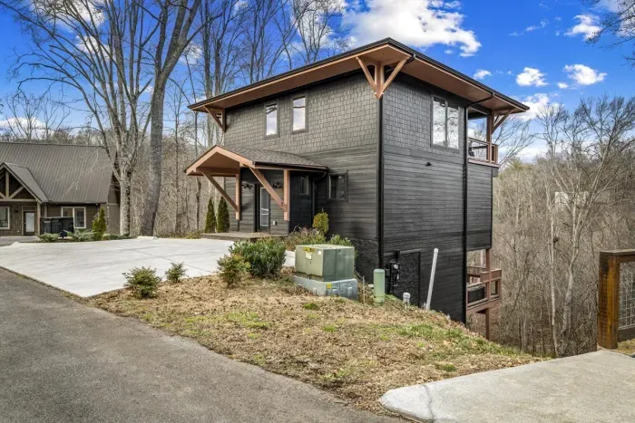 Contemporary two-story home with wooded surroundings.