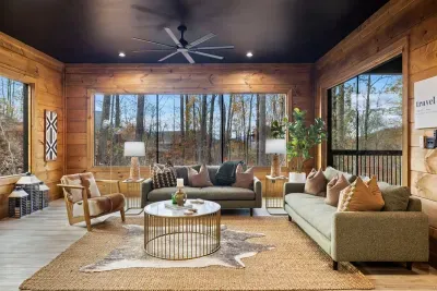 Professionally decorated living room with view of wooded area