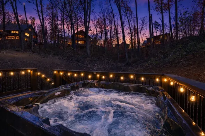 Hot tub on deck overlooking wooded area.