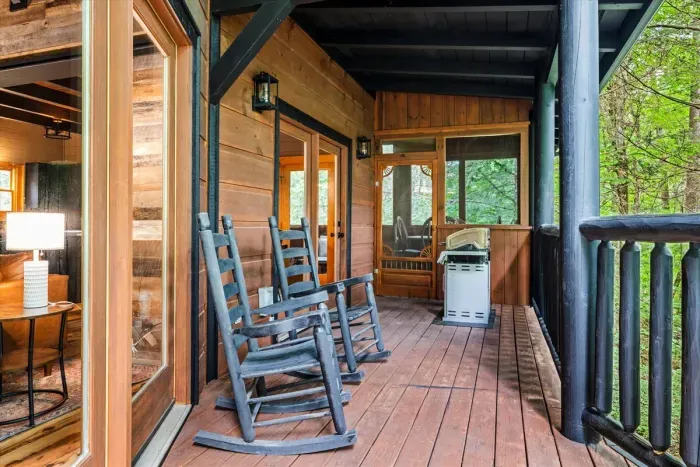 Large deck area with rocking chairs and grill