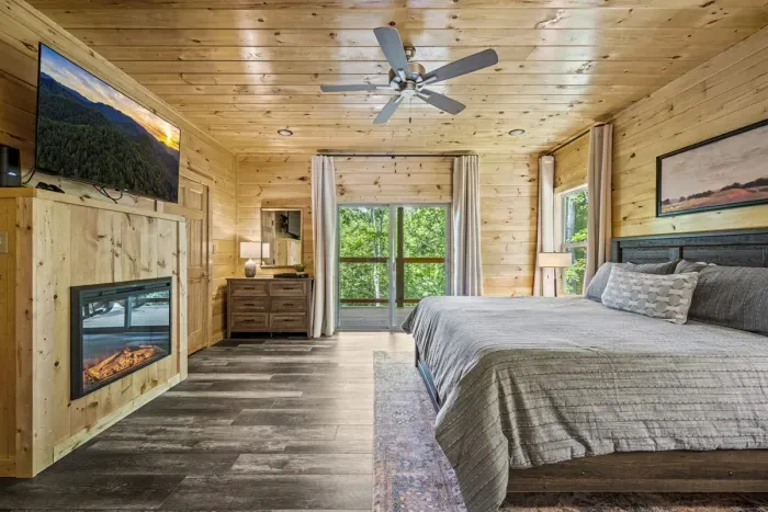 Master bedroom with electric fireplace and sliding doors to balcony