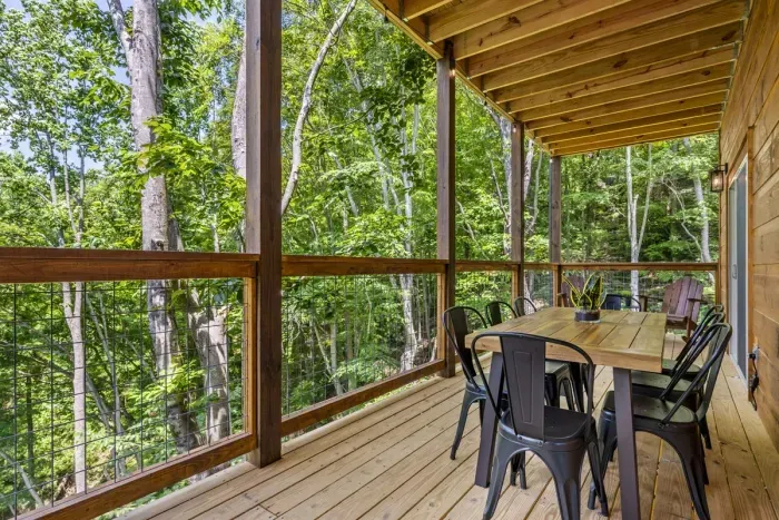 Outdoor seating on main level overlooking wooded area