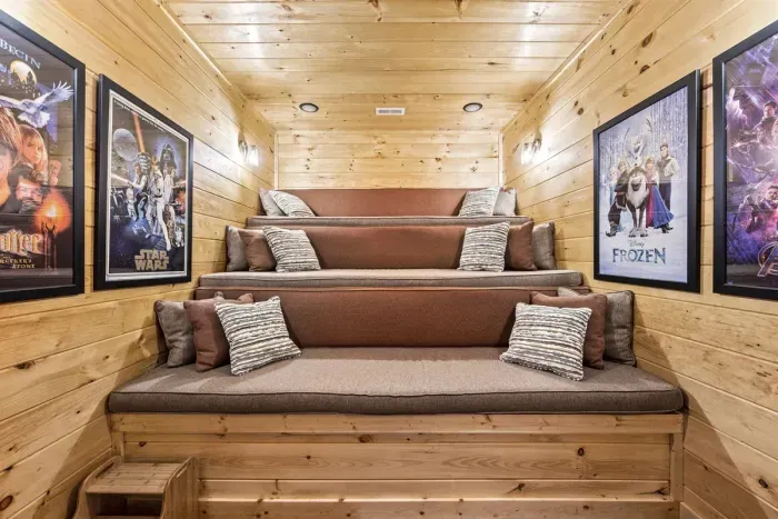 Theater Room with cushioned tiered seating, 65” Smart TV, & Sonos sound bar