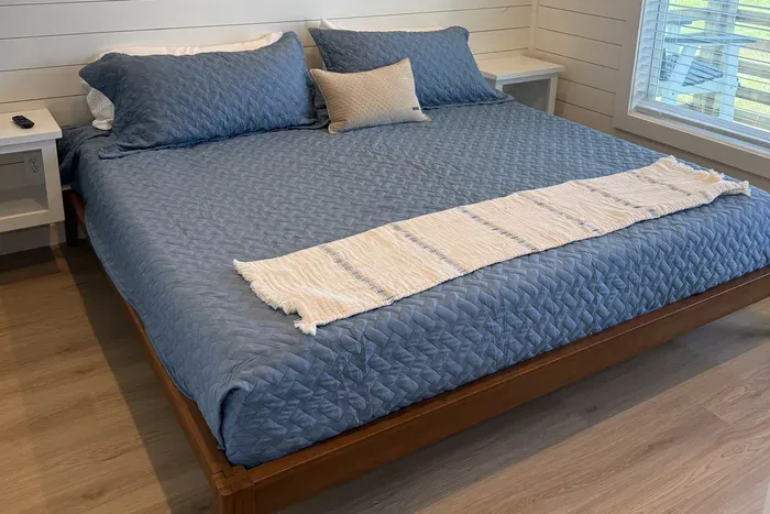 A bright and inviting bedroom designed for a perfectly restful stay. Enjoy spacious comfort and cozy coastal tones after a day of exploring.