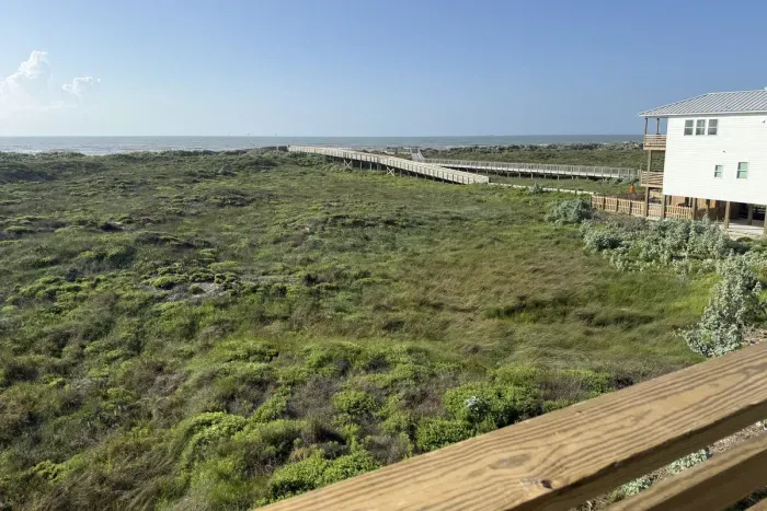 Just steps from the sand. Take a scenic stroll down the wooden boardwalk right to the beach, completely surrounded by beautiful coastal greenery.