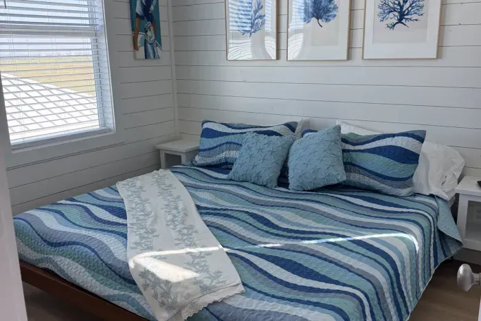 A peaceful retreat after a day at the beach. Unwind in a cozy, beautifully styled bedroom designed for a perfect night’s sleep.