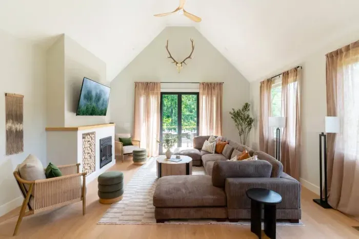 Scandinavian-inspired, this bright and airy living room features vaulted ceilings and an open flow to the kitchen and upper deck—complete with a 10-person dining table and grill for easy indoor-outdoor living. The fireplace is strictly decorative.