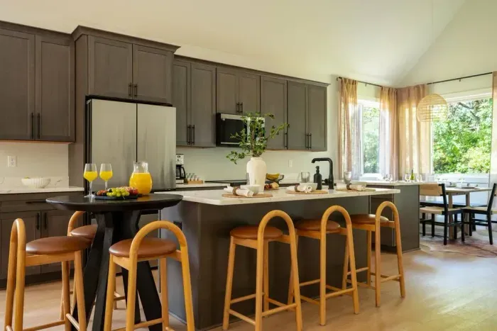 A fully stocked kitchen with sleek stainless appliances and plenty of seating at the island and nearby bar—perfect for cooking, snacking, or just hanging out while someone else does the cooking.