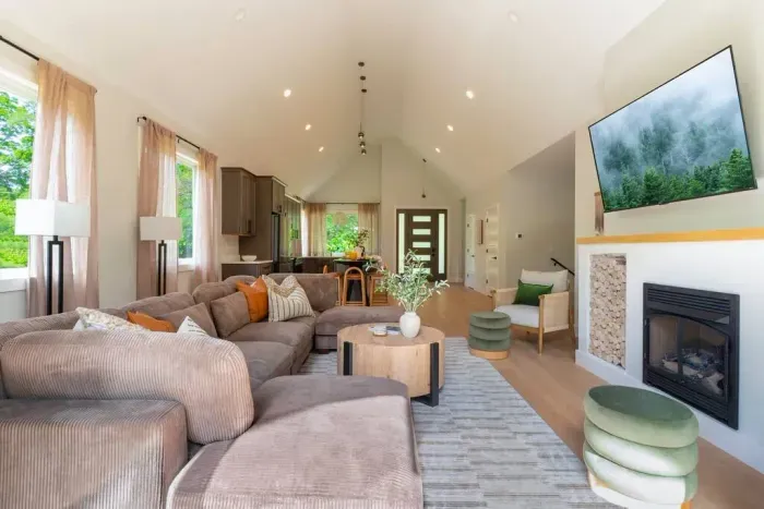 The bright, open living room flows effortlessly into the modern kitchen—perfect for gathering and relaxing. The indoor fireplace is decorative only and does not ignite, per insurance and safety regulations.