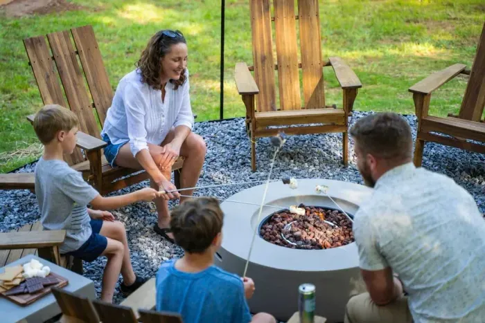 Tucked into the backyard under string lights, this spacious fire pit area seats eight in Adirondack chairs—perfect for evening hangs and easy conversation around the fire.