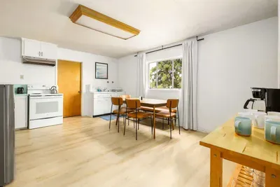 Sunny dining area with cool retro vibes, comfy seating, and a big window that brings the outdoors in, perfect spot for meals, coffee, or game night!