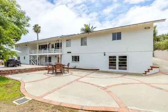 This spacious outdoor area features a charming patio with comfortable seating for al fresco dining and a sprawling lawn perfect for enjoying the California sunshine.
