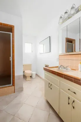 Bright and spacious full bathroom featuring a walk-in shower, vintage tile accents, and plenty of counter space. Equipped with all the essentials for a comfortable and convenient stay.