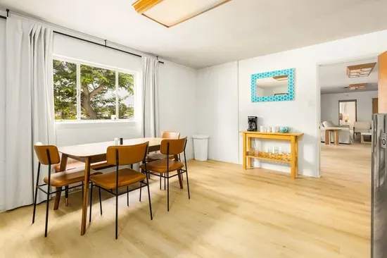 Bright and airy dining space with mid-century modern furnishings, a large picture window with lush views, and playful accent décor that adds charm and character to every meal!