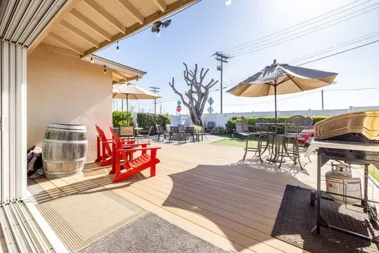 Soak up the sun on the spacious wooden deck or find shade under the umbrellas. With plenty of seating options, including high-top tables and lounge chairs for evening chats, this versatile outdoor area is your private escape to relax and unwind.