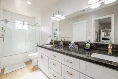 This bright, full bathroom combines style and function perfectly. The crisp white subway tile in the shower area pairs beautifully with the dark granite countertops and modern fixtures.