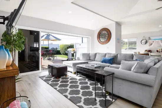 Relaxation comes easy in this bright and airy living room that opens directly onto a charming patio. Sink into the plush, modern gray sectional for a movie night on the large screen, or slide open the glass doors to enjoy the fresh air  area.