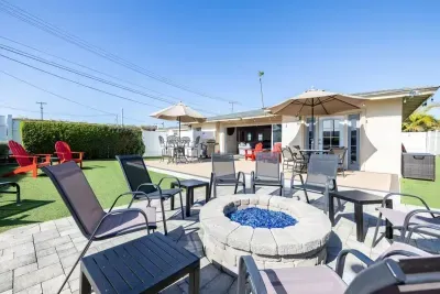 A vibrant backyard retreat with a fire pit, BBQ grill, and plenty of seating to relax under the sun or stars.