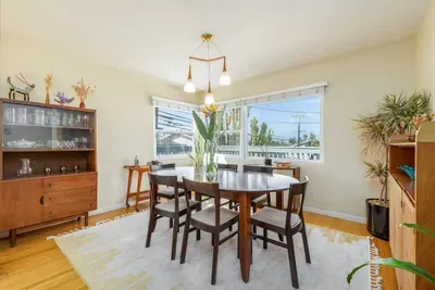 Gather around a stunning walnut oval dining table paired with matching high-back chairs, comfortably seating six guests.