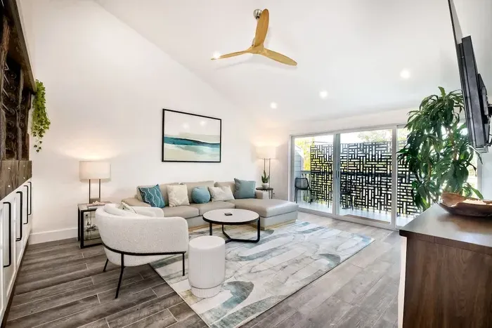 A wooden ceiling fan with a gold finish adds warmth to the space.
