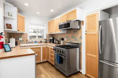 Whip up a fantastic feast in this bright, fully stocked kitchen featuring a professional-style stainless steel range, dishwasher, and a cozy dining nook.