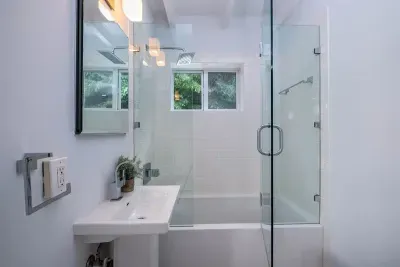 Modern guest house bathroom with Brio faucets and hair dryer