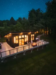 Tucked away on 24 acres of private woods, The Kimberly offers the perfect mix of modern design and peaceful seclusion. 1,000 sq ft. wrap around deck including hot tub, cold plunge, fire pit, grill and loungers. A stone path leads to the Kuro sauna.