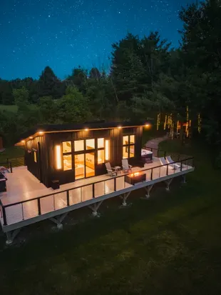 Tucked away on 24 acres of private woods, The Kimberly offers the perfect mix of modern design and peaceful seclusion. 1,000 sq ft. wrap around deck including hot tub, cold plunge, fire pit, grill and loungers. A stone path leads to the Kuro sauna.