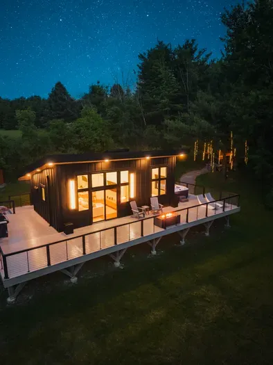 Tucked away on 24 acres of private woods, The Kimberly offers the perfect mix of modern design and peaceful seclusion. 1,000 sq ft. wrap around deck including hot tub, cold plunge, fire pit, grill and loungers. A stone path leads to the Kuro sauna.