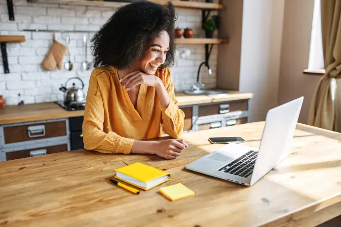 Woman working remotely from kitchen counter of her vacation rental