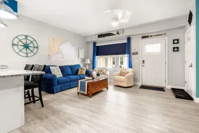 Open living room & kitchen, with mounted smart TV, Dining table, strong WiFi, sleeper sofa and fully-equipped kitchen