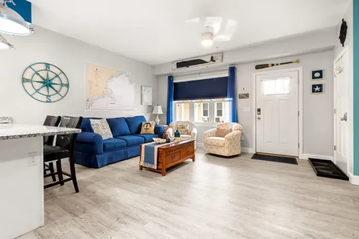 Open living room & kitchen, with mounted smart TV, Dining table, strong WiFi, sleeper sofa and fully-equipped kitchen