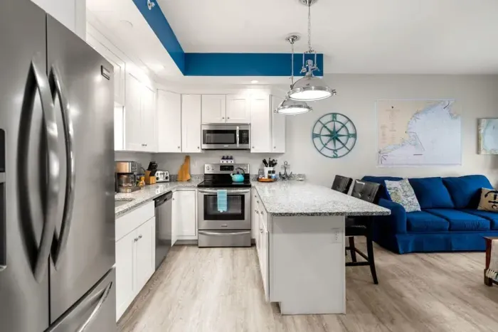 Open living room & kitchen, with mounted smart TV, Dining table, strong WiFi, sleeper sofa and fully-equipped kitchen