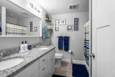 Bedroom with queen bed, en-suite bathroom with double sink, stand up shower and stackable washer/dryer