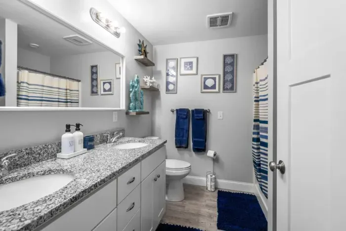 Bedroom with queen bed, en-suite bathroom with double sink, stand up shower and stackable washer/dryer