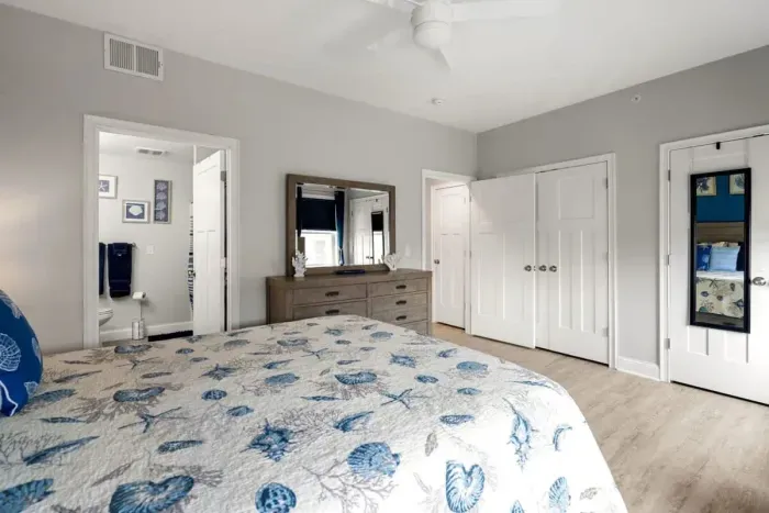 Bedroom with queen bed, en-suite bathroom with double sink, stand up shower and stackable washer/dryer