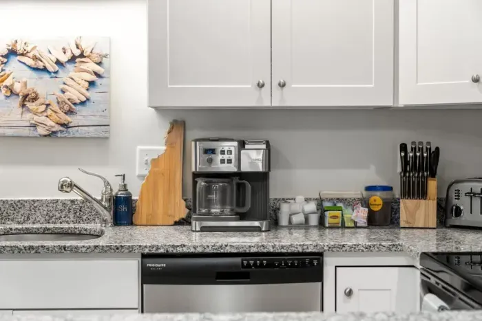 Open living room & kitchen, with mounted smart TV, Dining table, strong WiFi, sleeper sofa and fully-equipped kitchen