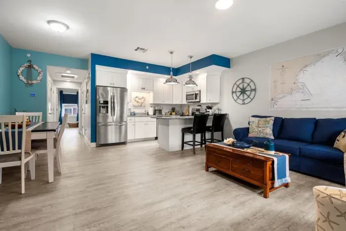 Open living room & kitchen, with mounted smart TV, Dining table, strong WiFi, sleeper sofa and fully-equipped kitchen