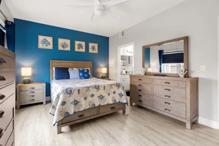 Bedroom with queen bed, en-suite bathroom with double sink, stand up shower and stackable washer/dryer