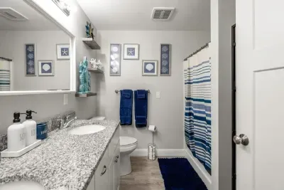 Bedroom with queen bed, en-suite bathroom with double sink, stand up shower and stackable washer/dryer