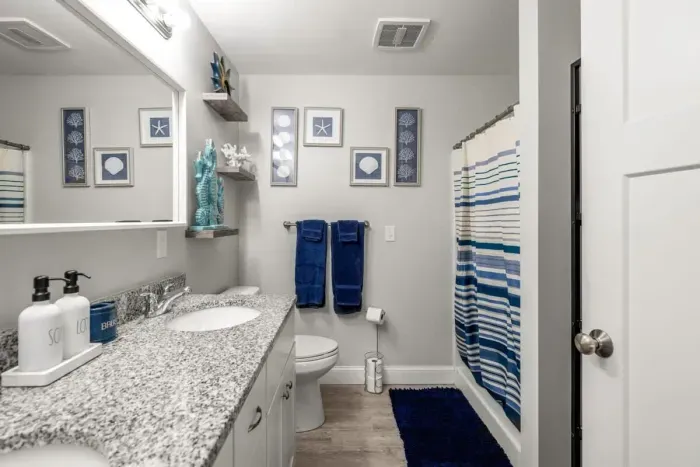 Bedroom with queen bed, en-suite bathroom with double sink, stand up shower and stackable washer/dryer